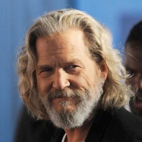 A man outdoor smiling with his Jeff Bridges hairstyle