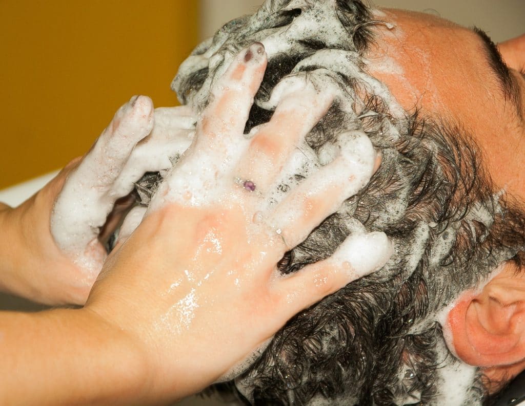 a man having his hair wash with shampoo