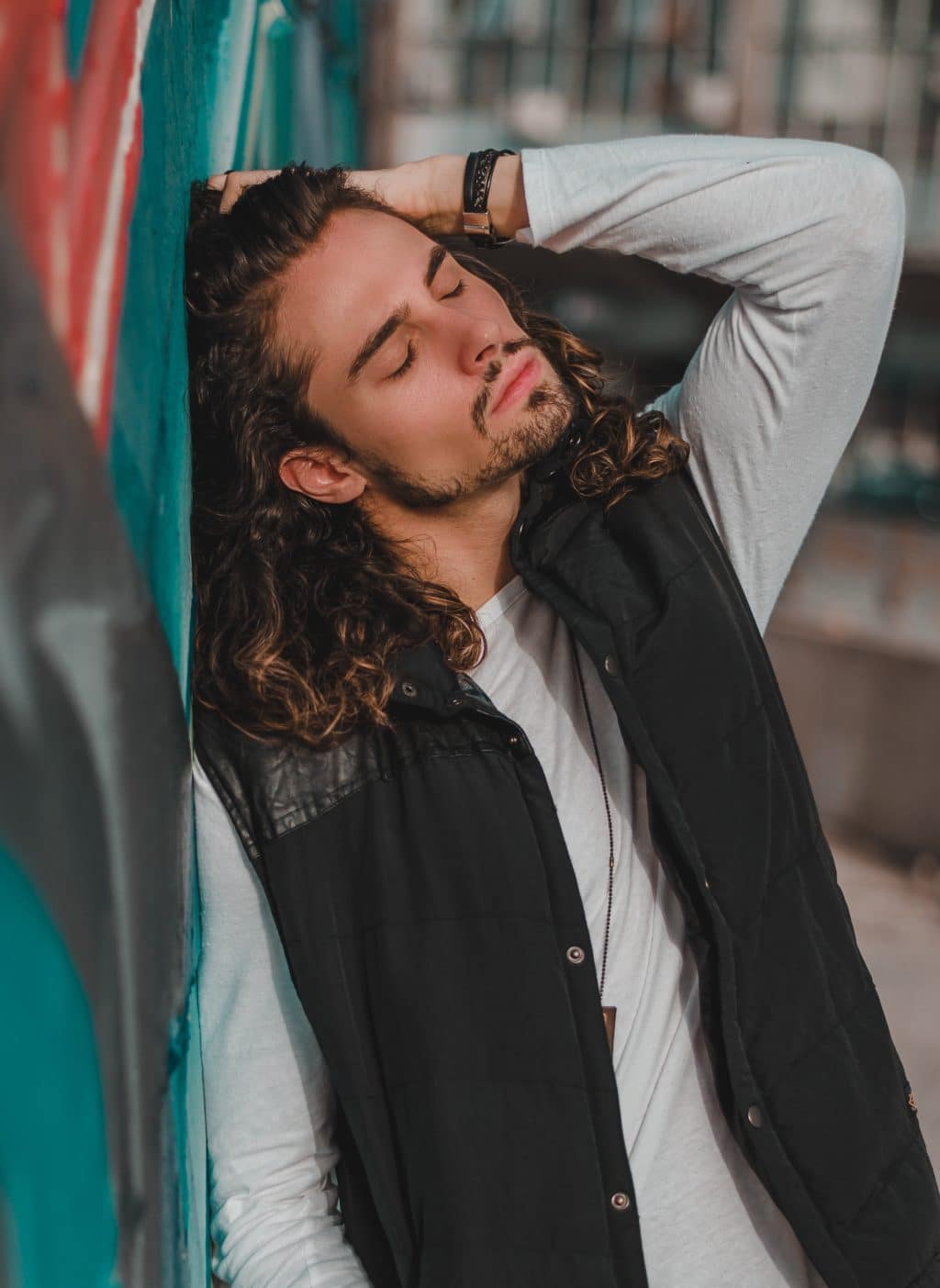 man with curly hairstyle dramatically posing