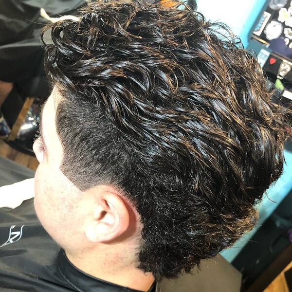 Black Textured Mullet with Taper Fade- a man wearing a black barber's cape Baseball Haircuts