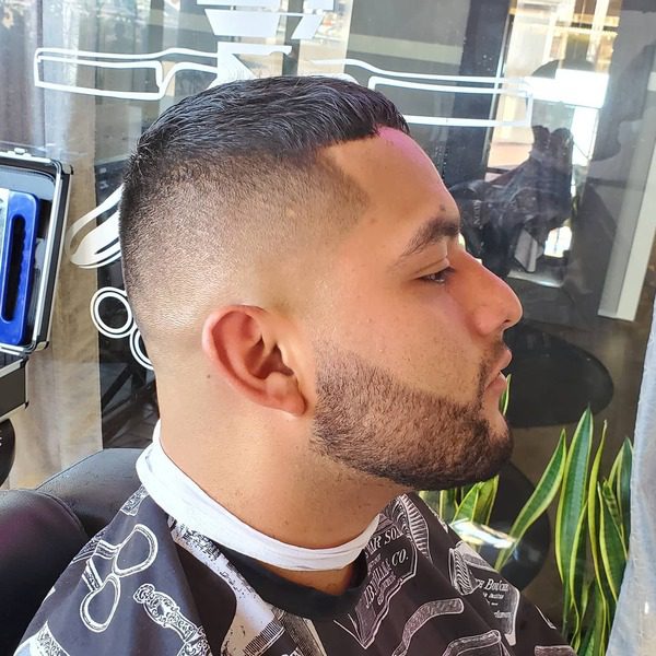 Crew Cut with Skin Fade- a man wearing a black barber's cape