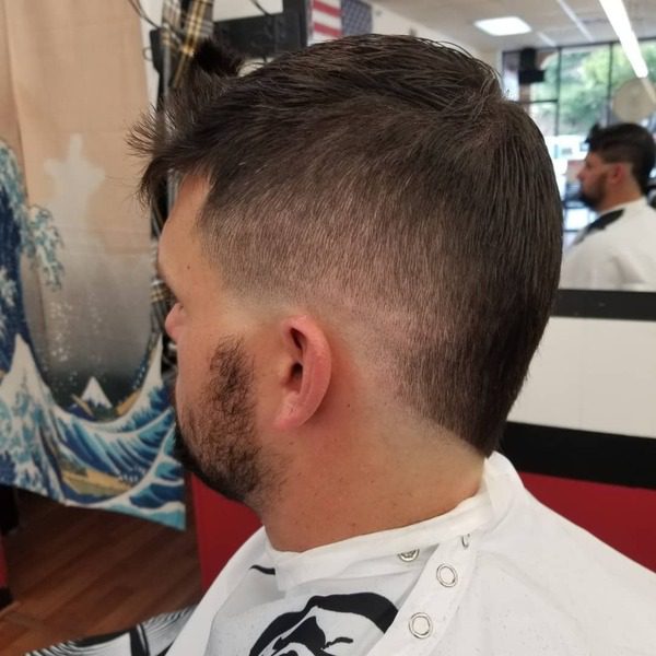 Faux Hawk with Burst Fade- a man wearing a white barber's cape