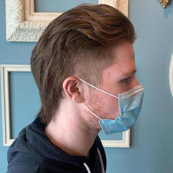 Faux Hawk with Mid Fade- a man wearing a blue face mask and wearing a black jacket Baseball Haircuts