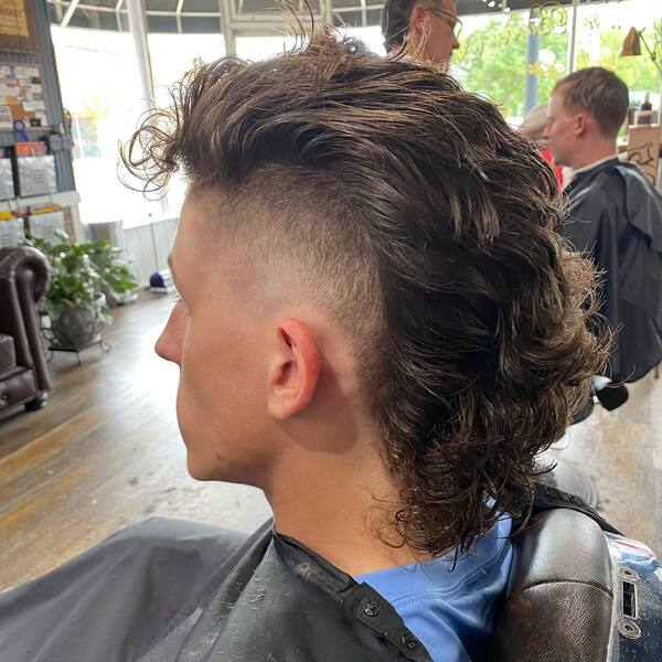 Long Messy Mullet- a man wearing a black barber's cape