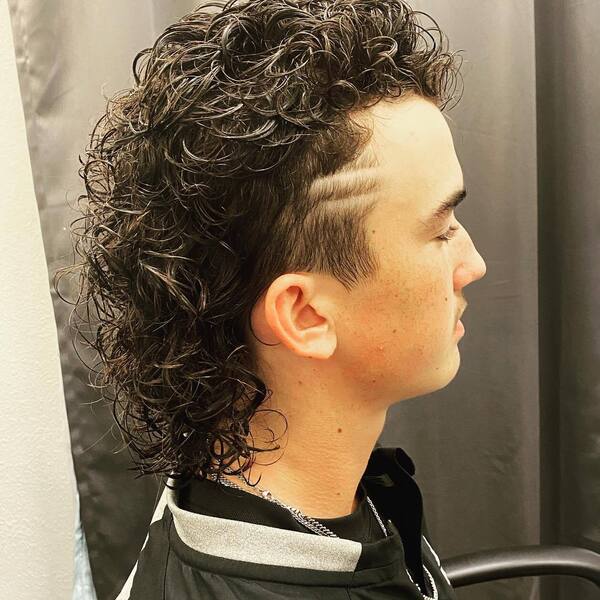 Messy Curls Mullet- a man wearing a black jacket Baseball Haircuts