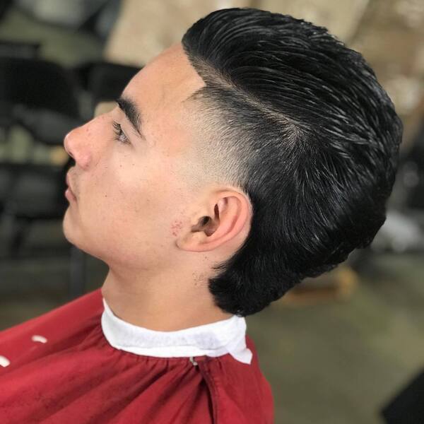 Slicked Back Mexican Mullet- a man wearing a red barber's cape Baseball Haircuts