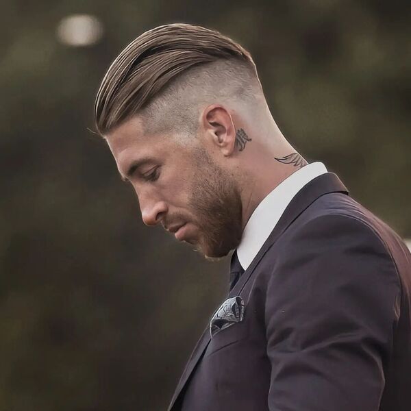 Slicked Back with High Skin Fade- A man wearing a formal black suit