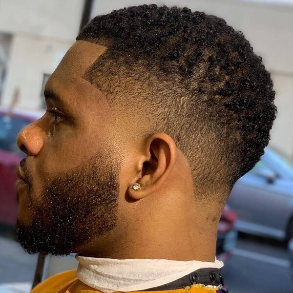 Sponge Hairstyles for Black Men- a man wearing a barber's cape