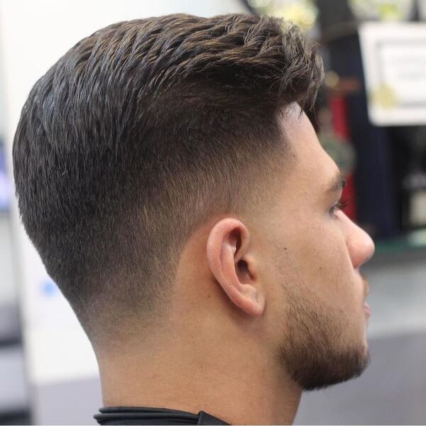 Textured Comb Over with Mid Fade- a man wearing a black jacket Baseball Haircuts
