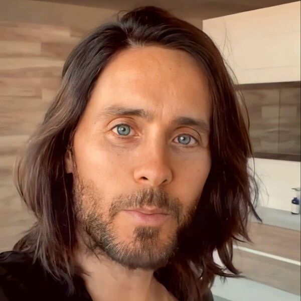 Wavy Dry Side Part- Jared Leto wearing a black polo