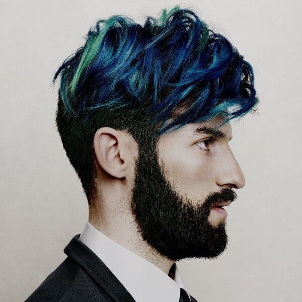 a man in side view with his green and blue hair