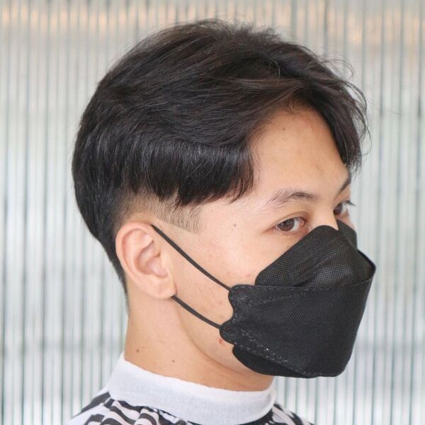 A man wearing black mask with curtain haircut