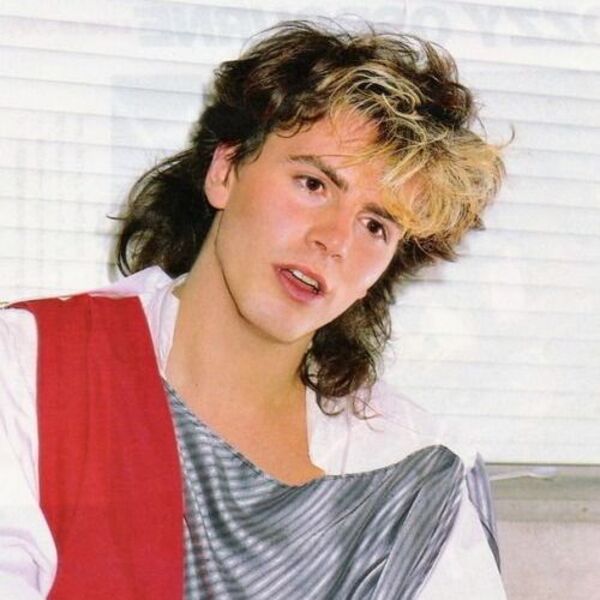 a man with a wavy shoulder length hair  a 80s hairstyles for men